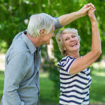 Senior couple dancing in park