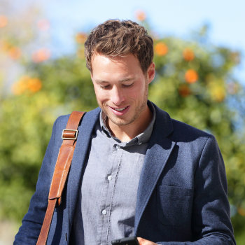 Young urban businessman smiles at the phone