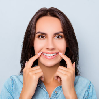 beautiful woman points fingers at her smile