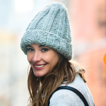 cute girl in a big winter hat smiles
