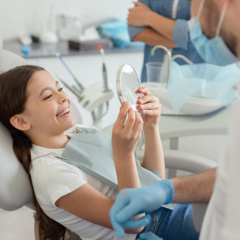 Cropped shot of girl looking in the mirror after dental procedure.