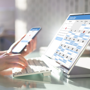 Person planning calendar schedule with pen and notebook on office desk, representing appointment scheduling and quick contact.