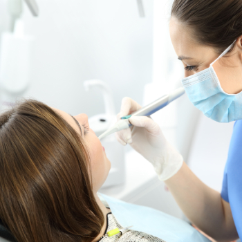 Close up of a dentist working with a patient teeth sitting on a chair in a clinic.